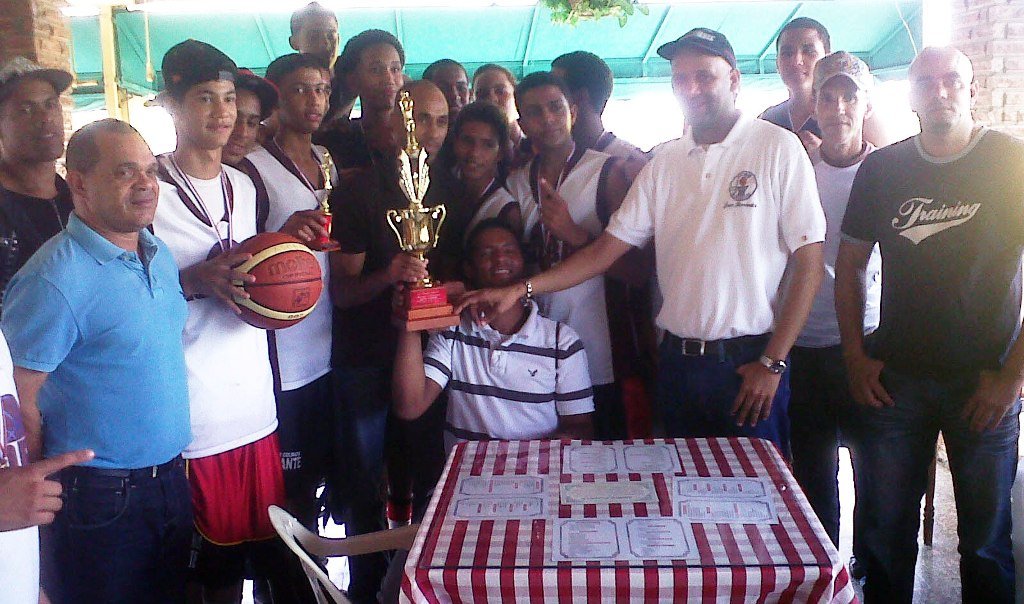 Juan Hernández presidente de ASOBAE, Vladimir Frías y Elvis Arroyo con jugadores y directivos celebran el campeonato regional de baloncesto juvenil.